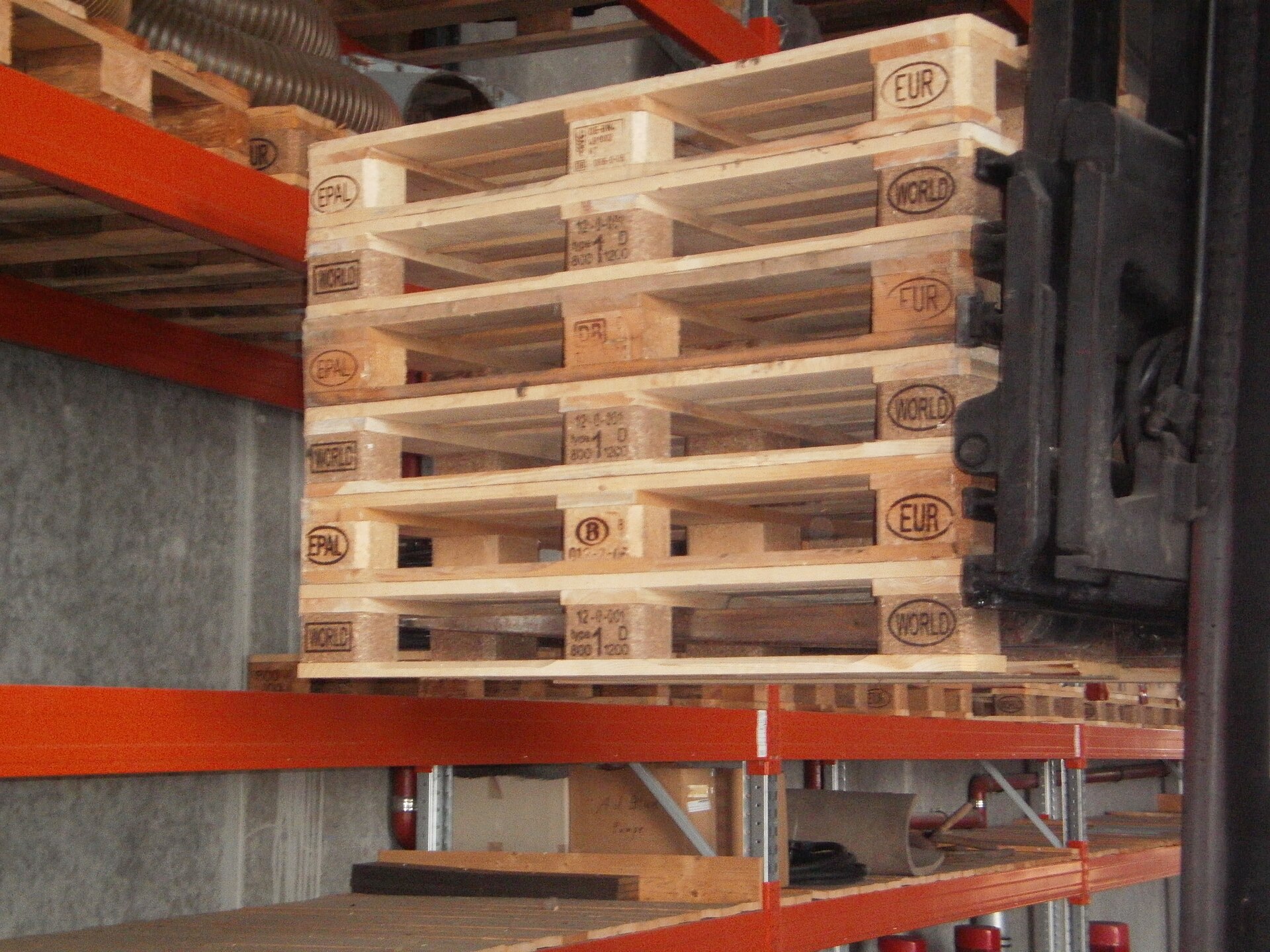 Stacked wooden Euro pallets in a warehouse.