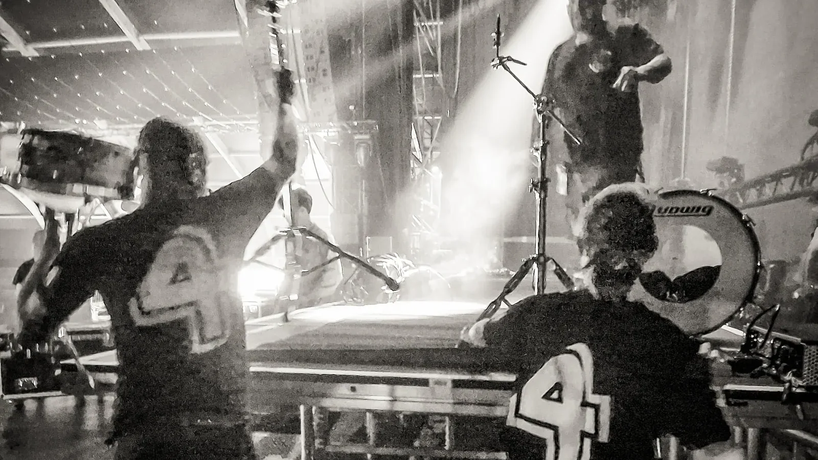 Stagehands in het zwart naast een verlicht festivalpodium